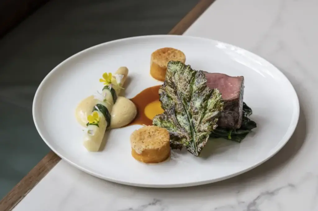 Hereford Beef Fillet with White Asparagus, Mustard Greens, Confit Garlic, and Parmesan by Robert Chambers, GBC